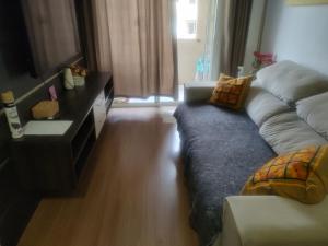 a living room with a couch and a television at Veredas do bosque in Curitiba