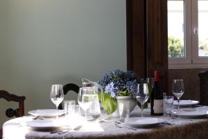 una mesa con copas de vino y un jarrón de flores en Casa Brandao, en Vale de Cambra