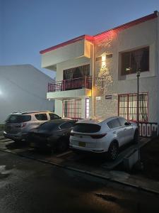zwei Autos auf einem Parkplatz vor einem Gebäude geparkt in der Unterkunft apartaestudios las astromelias salento in Salento