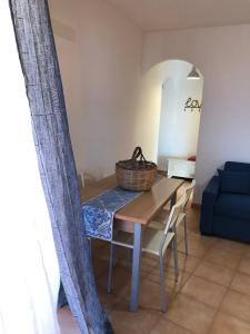 een eettafel en stoelen met een mand erop bij Appartamenti Perego in Castelsardo