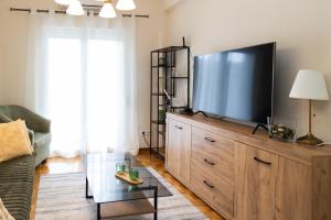 een woonkamer met een grote televisie op een houten dressoir bij Santa Marina 2 in Ioannina