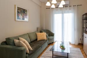 een woonkamer met een groene bank en een glazen tafel bij Santa Marina 2 in Ioannina
