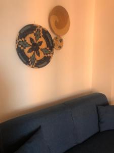 twee borden hangend aan een muur naast een bank bij Appartamenti Perego in Castelsardo