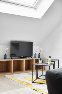 a living room with a flat screen tv on a entertainment center at Le Grand Bleu - Wifi fibre/Linge/Accès cour in Saint-Mars-la-Jaille