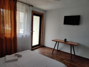 1 dormitorio con cama, mesa y ventana en Casa Vlad, en 23 August
