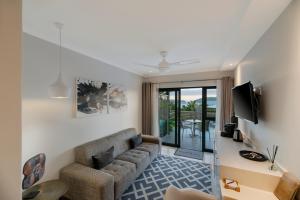 a living room with a couch and a tv at THEBLOEM Guest Suites by Knysna Paradise Collection in Knysna