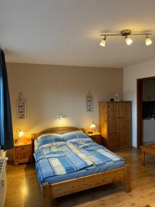 Schlafzimmer mit einem Bett mit blauer Decke in der Unterkunft "Alte Sparkasse" Nr2 in Landkirchen