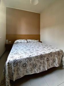 una camera da letto con un letto con copriletto floreale di Appartamento Castiglioni a Grandate