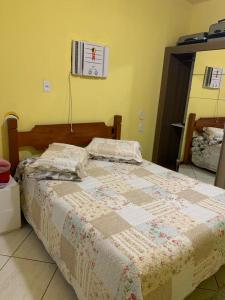 un letto con una trapunta in una camera da letto di Apartamento em Torres acolhedor! a Torres