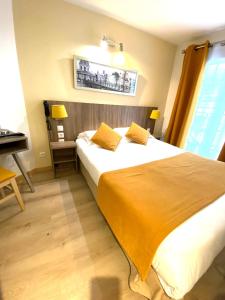 パリにあるオテル マザグランのベッドルーム1室(黄色いシーツとデスク付)