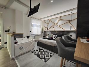 a bedroom with a tub and a bed and a couch at saige holidays in Alghero