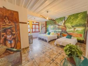 una camera con due letti e un dipinto sul muro di Eco Hotel El Refugio de La Floresta a Leticia