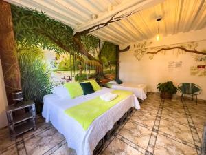 two beds in a room with a painting on the wall at Eco Hotel El Refugio de La Floresta in Leticia