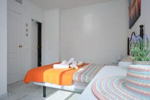 um quarto com uma cama com um cobertor laranja em NFN Apartment Los Hidalgos Golf em Manilva