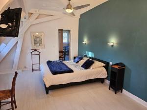 1 dormitorio con 1 cama con pared azul en La demeure aux Pins, en Lourdes