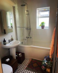 ein Bad mit einer Badewanne, einem Waschbecken und einer Dusche in der Unterkunft 4 Birkbeck Road Beckenham BR3 4SN in Elmers End