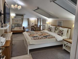 ein Schlafzimmer mit einem großen Bett und ein Wohnzimmer in der Unterkunft Hotel Odeon in Plowdiw