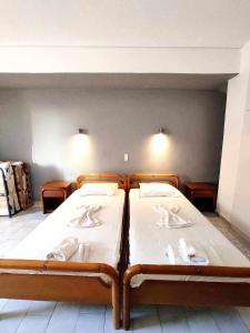 - une chambre avec 2 lits et des draps blancs dans l'établissement Politis Sudios, à Batsi