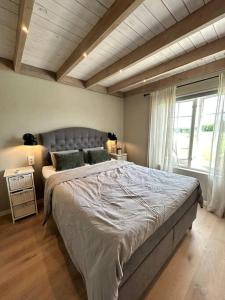 a bedroom with a large bed and a window at Gezellig huisje met mooi uitzicht in Holmestrand