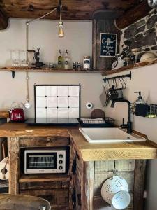 a kitchen with a sink and a microwave at Cà d’la Giannina • local experience Valle Antrona in Pallanzeno