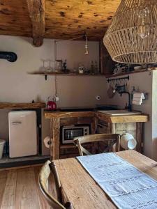 a kitchen with a wooden table and a kitchen with a stove at Cà d’la Giannina • local experience Valle Antrona in Pallanzeno