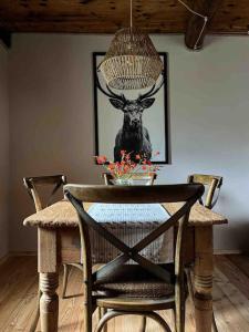 a table with a picture of a deer on the wall at Cà d’la Giannina • local experience Valle Antrona in Pallanzeno