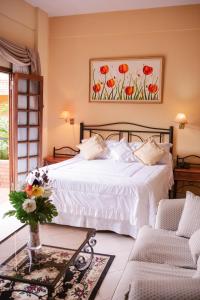 a bedroom with a white bed and two chairs at Hotel Santo Domingo in Asuncion