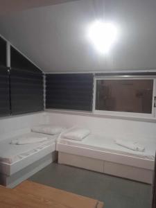 a white bathroom with two sinks and a window at Kalymnos Platy Gialos Mousellis Makis Apartments in Kalymnos