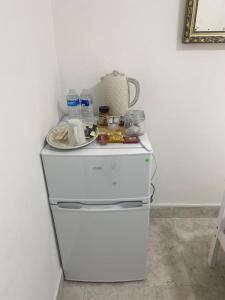 a white refrigerator with a plate on top of it at Airstaybnb in Manchester