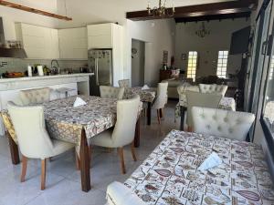 a dining room with tables and chairs and a kitchen at Like at Home Ezeiza in Ezeiza