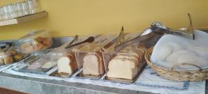 una mesa con una bandeja de pan y una cesta de comida en Pousada Nanina de Geribá, en Búzios