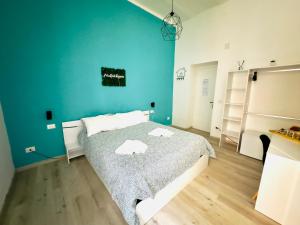 1 dormitorio con 1 cama con pared azul en Altopiano Rooms, en Foggia