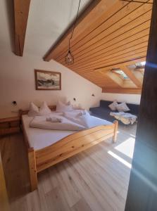 a large bed in a room with wooden ceilings at Haus Marinus in Jerzens