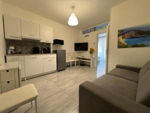 ein Wohnzimmer mit einem Sofa und einer Küche in der Unterkunft Appartamento Suite Galatea in Pozzallo