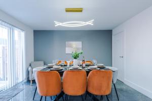 a dining room with a table and orange chairs at Stays Lilies House in Chester