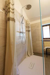 um chuveiro com uma porta de vidro na casa de banho em Hotel Park Oasi em Arta Terme