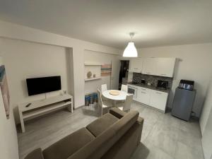 sala de estar con sofá, mesa y cocina en Appartamento suite Anfitrite, en Pozzallo
