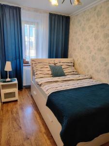 - une chambre avec un grand lit et des rideaux bleus dans l'établissement Apartament Śródmieście, à Łańcut