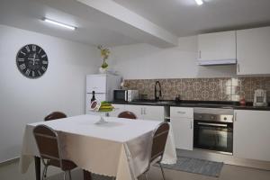 kuchnia ze stołem i zegarem na ścianie w obiekcie Fifty's House 2 w mieście Ribeira Brava