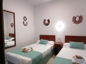 1 dormitorio con 2 camas y espejo en CN-340 Suites, en Estepona