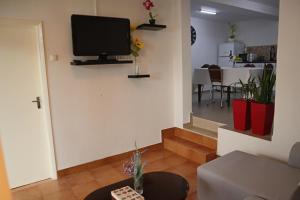 a living room with a flat screen tv on the wall at Fifty's House 2 in Ribeira Brava