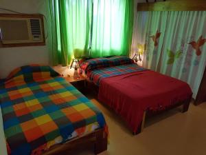 two beds in a room with green and colorful at Casa SAMI Acepto Mascota in Ayampe