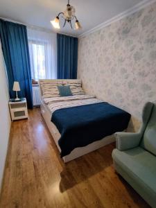 a bedroom with a large bed and a couch at Apartament Śródmieście in Łańcut