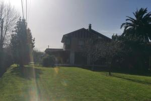 a house with a grassy yard next to a house at Apartamento 3 habitaciones en casa, amplio jardín in Liaño