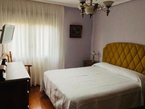 a bedroom with a white bed and a window at Apartamento 3 habitaciones en casa, amplio jardín in Liaño
