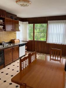 Apartamento 3 habitaciones en casa, amplio jardín في Liaño: مطبخ مع طاولة وكراسي في مطبخ