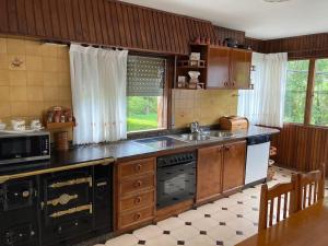 a kitchen with a sink and a stove top oven at Apartamento 3 habitaciones en casa, amplio jardín in Liaño