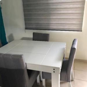 a white table and chairs in a room with a window at Alojamiento privado con seguridad in Tepic