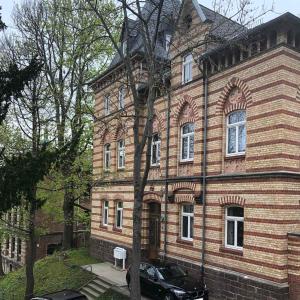 a brick building with a car parked in front of it at Marktresidenz Eisenach- Stilvolle Maisonette mit 3 Zimmern und 2 Bädern in Eisenach
