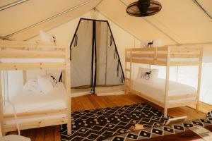 a room with two bunk beds in a tent at Deluxe Glamping Tents at Lake Guntersville State Park in Guntersville
